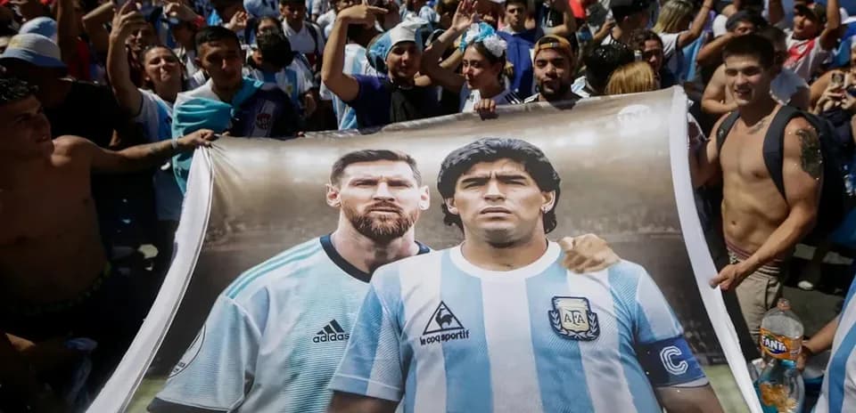Fans holding banner of Messi and Maradona at celebration