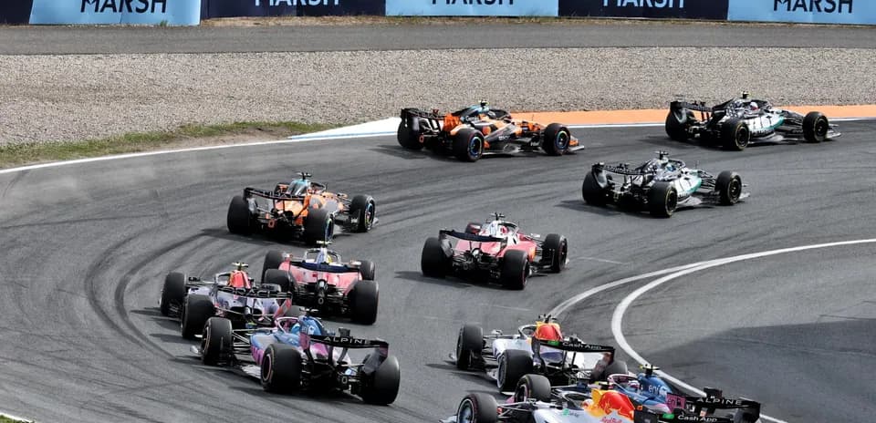 Formula 1 cars racing around a tight curve
