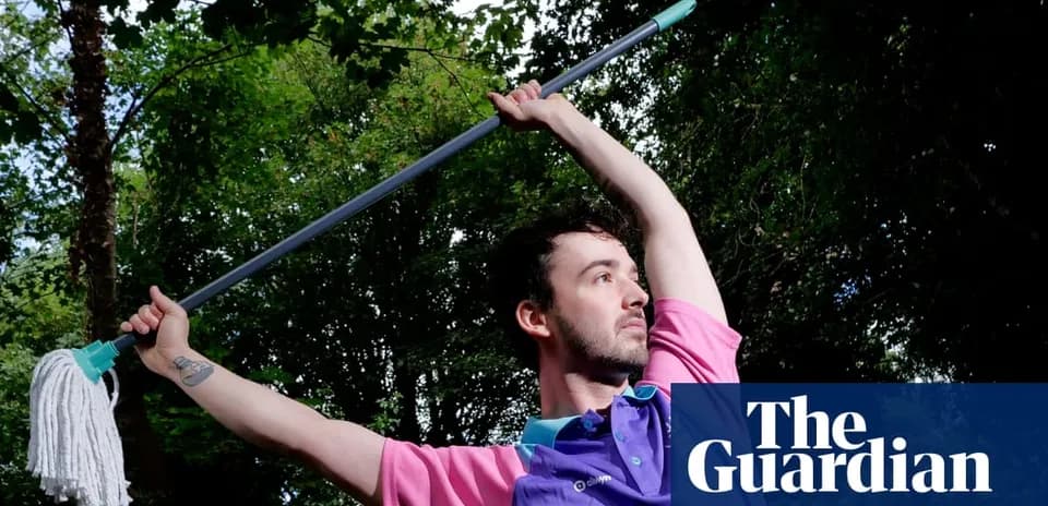 Shirtless person posing with a mop outdoors
