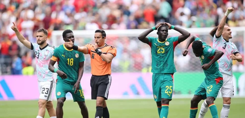 Senegal players reacting during a match with referee