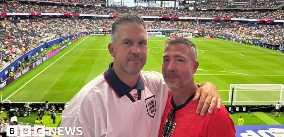 Two fans posing at stadium during a match