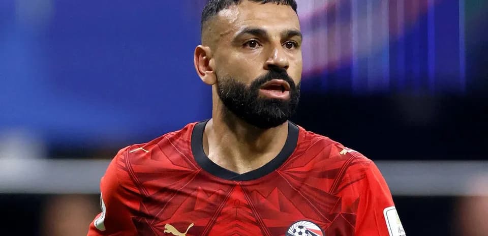 Futbolchi qizil futbolka kiygan, harakatda