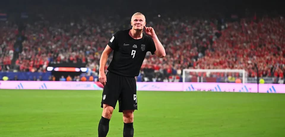 Futbolchi maydonda qo'lini quloq tomon qo'ygan