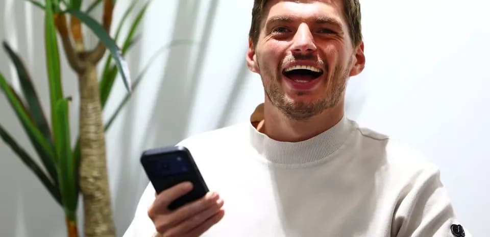 Yigit telefon ushlab, kulayotgan odam