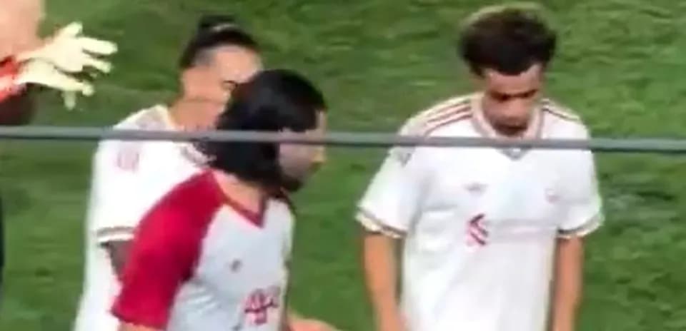 Football players on the sidelines during match