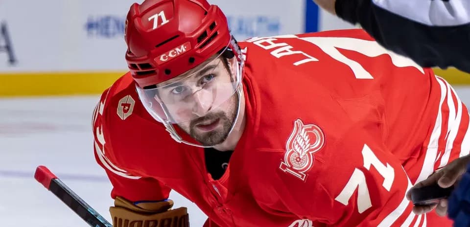 Hockey player in red jersey preparing for faceoff