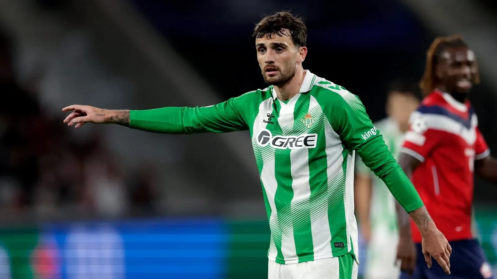 Futbolchi maydonda harakat qilmoqda, Real Betis formasi