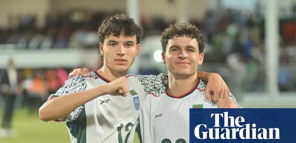 Ikkita futbolchi maydonda qo'llarini ko'targan