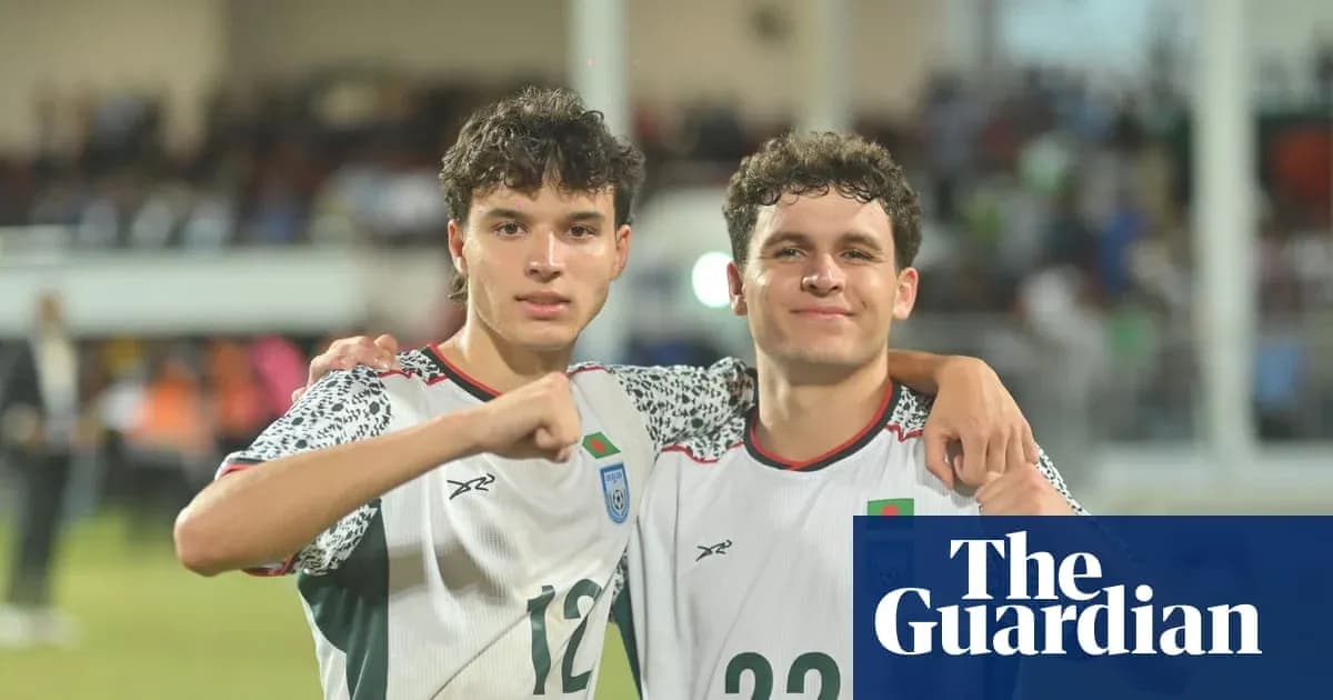 Ikkita futbolchi maydonda qo'llarini ko'targan
