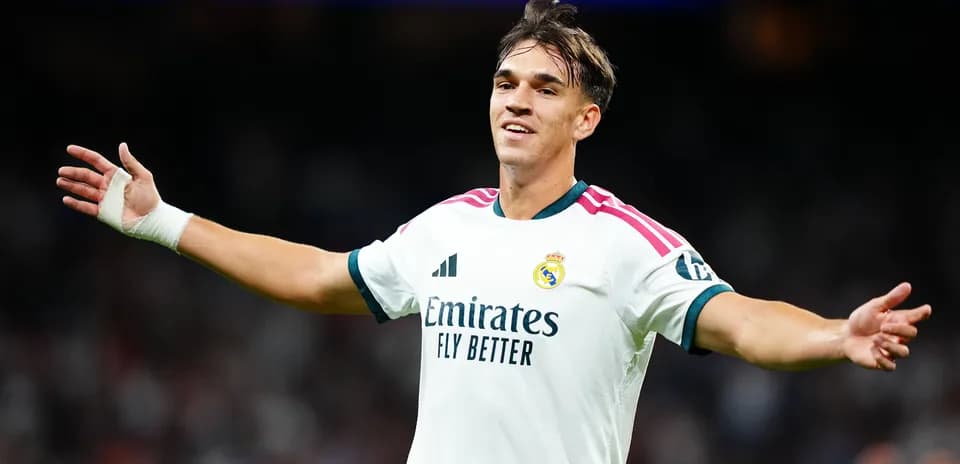 Futbolchi Real Madrid formasida maydonda qo'llarini ochmoqda