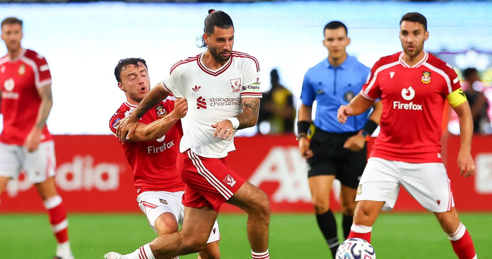 Futbol o'yinida ikki o'yinchi kurashmoqda