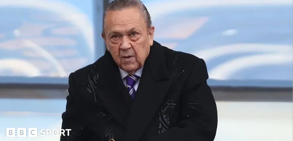 Man in black coat at sports venue