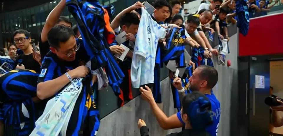 Futbolchi imzolarni berish uchun muxlislar bilan muloqot qilmoqda