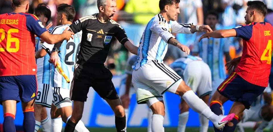 Players clashing during match with referee intervening