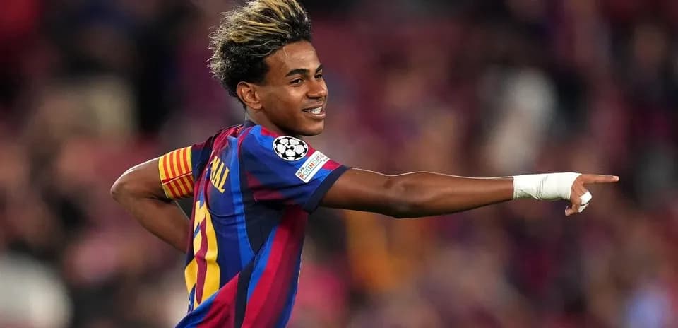 Futbolchi maydonda qo'lini ko'tarib nishonlayapti