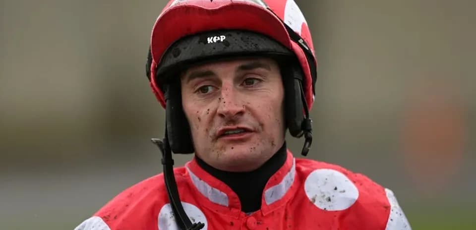 Jockey wearing red and white uniform after race