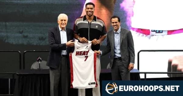 Player holding Miami Heat jersey with team officials