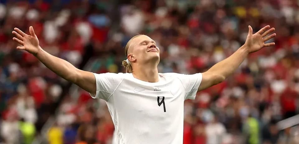 Futbolchi qo'llarini ochib, maydonda turibdi