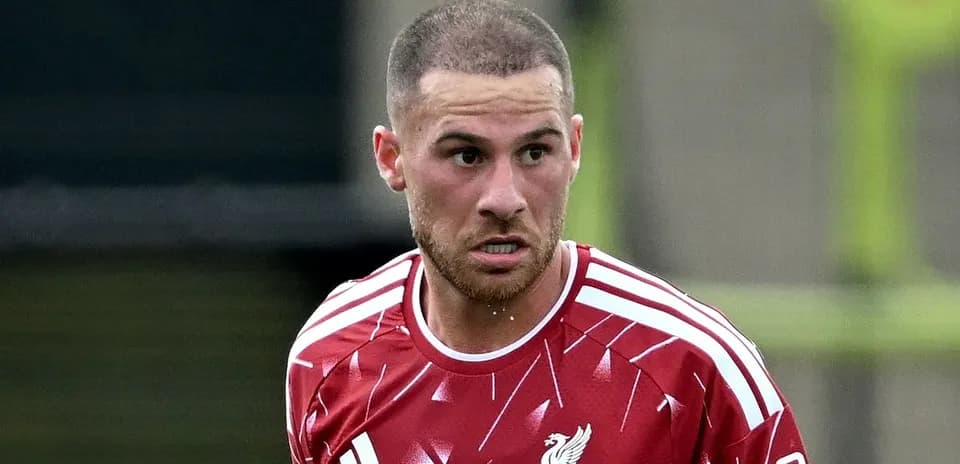 Futbolchi qizil forma kiygan o'yin maydonida
