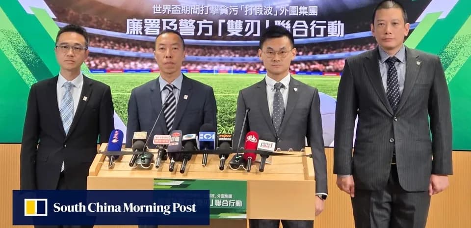 Four officials at a press conference with microphones