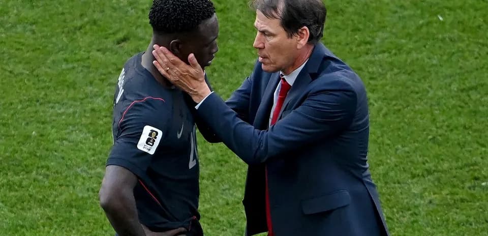 Coach speaking to player on the field