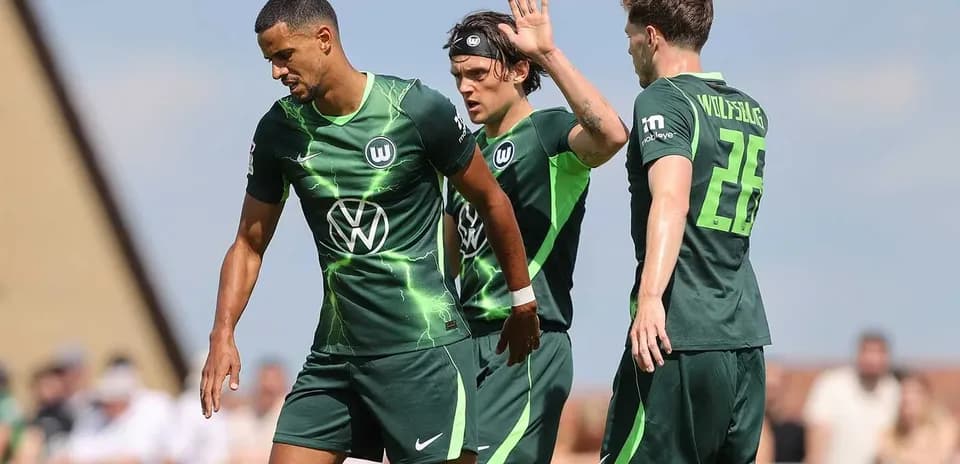 Wolfsburg players during match celebrating a goal