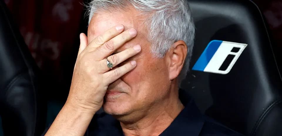Coach covering face with hand on bench