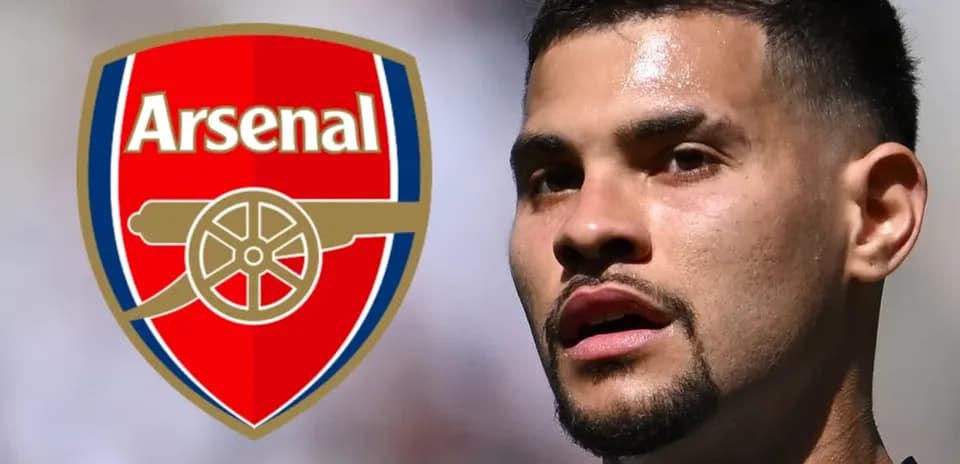 Futbolchi Arsenal logosi oldida turibdi