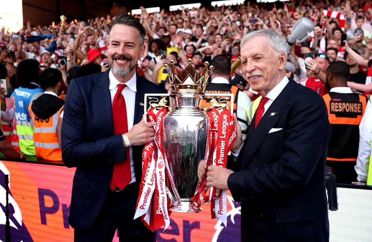 Two officials holding Premier League trophy with fans