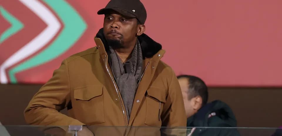 Man in brown coat observing from a stand