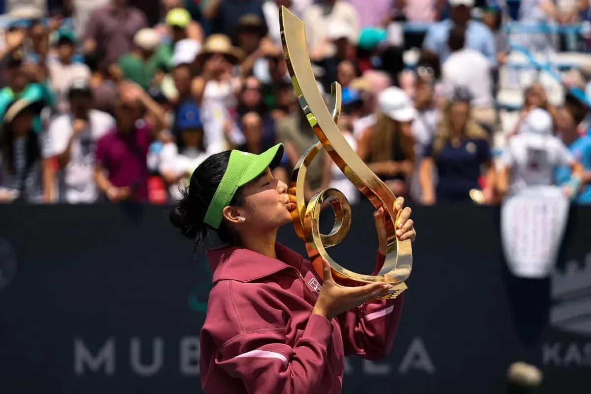 Tennis player kissing trophy on court