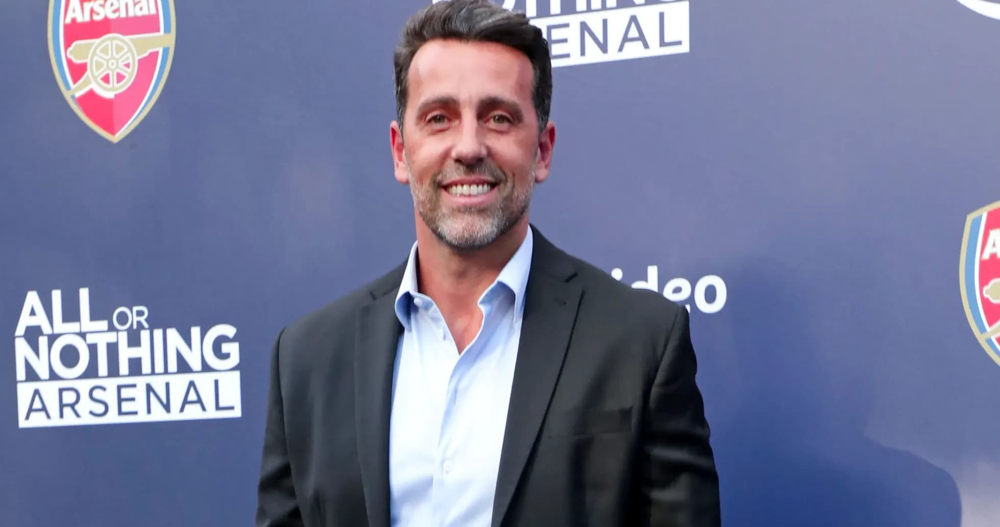 Man in suit at Arsenal event backdrop