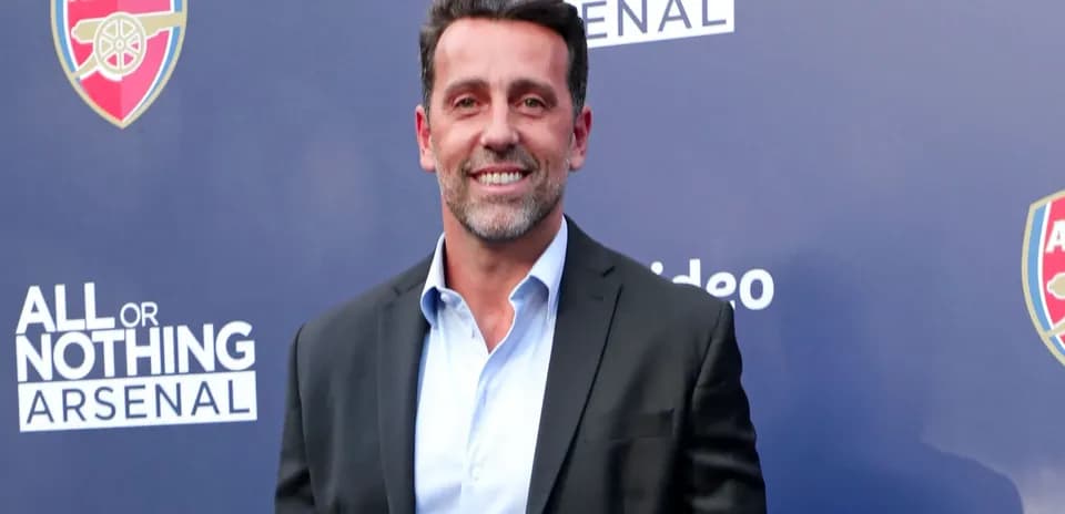 Man in suit at Arsenal event backdrop