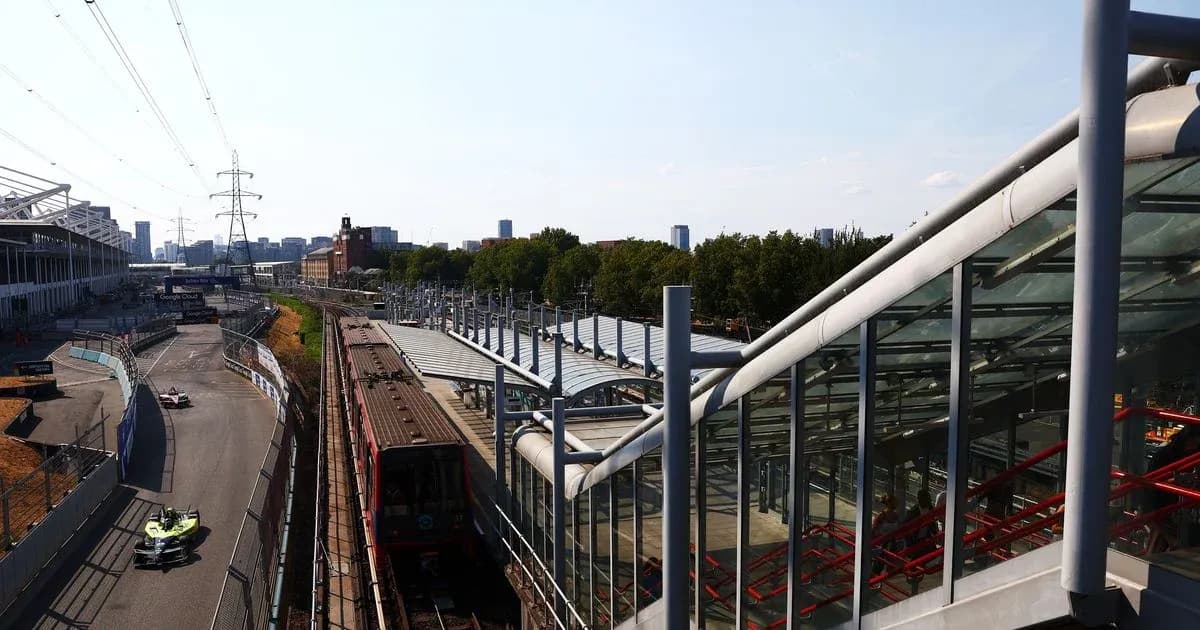 Formula E car racing near railway station and skyline