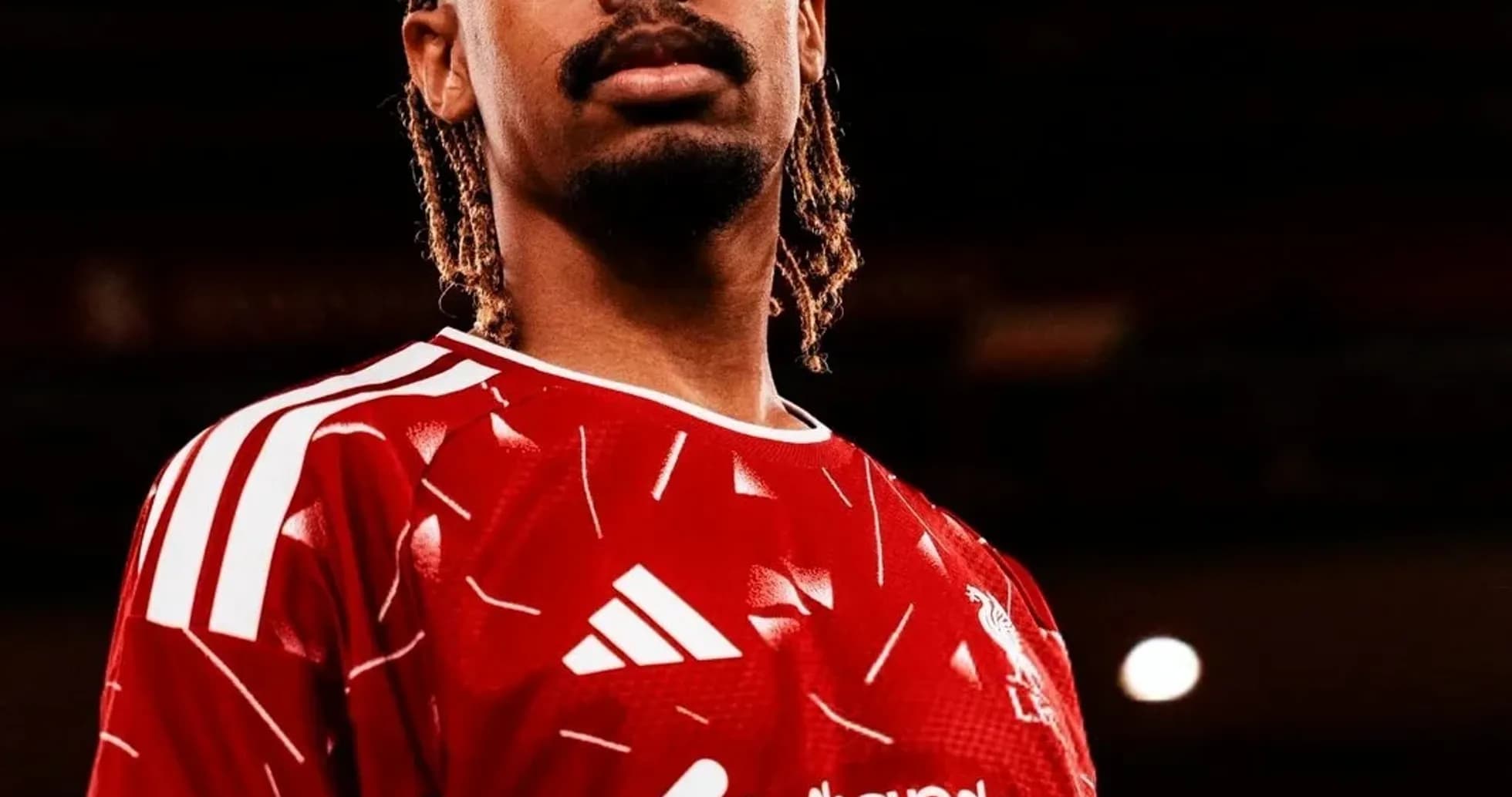 Futbolchi qizil formada poz berayotgan