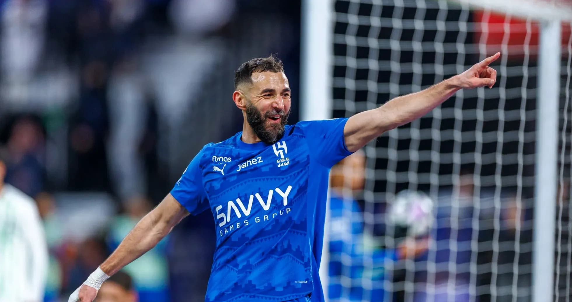 Futbolchi gol urib, qo'lini ko'tarib nishonlayapti