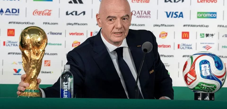 FIFA president presenting World Cup trophy at podium