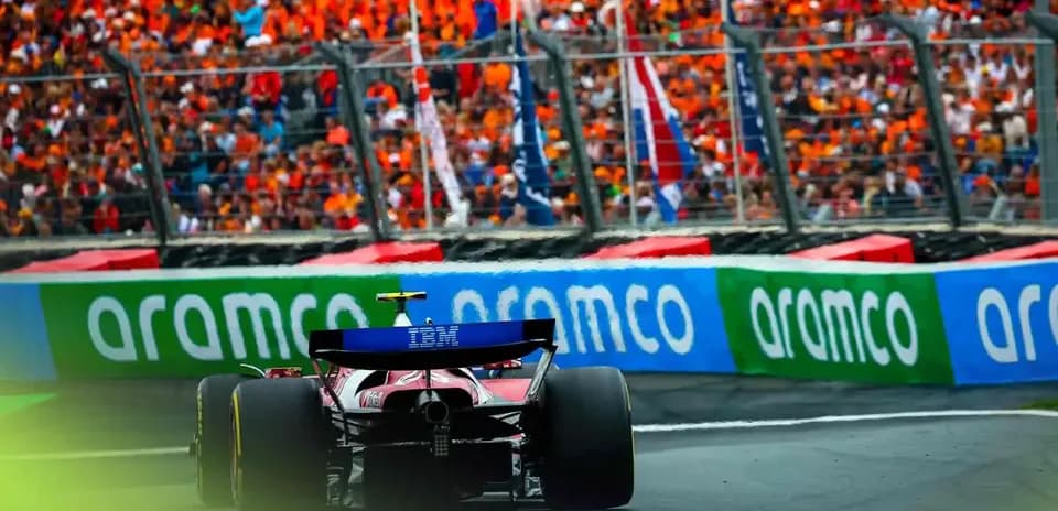 Formula 1 car racing past cheering crowd