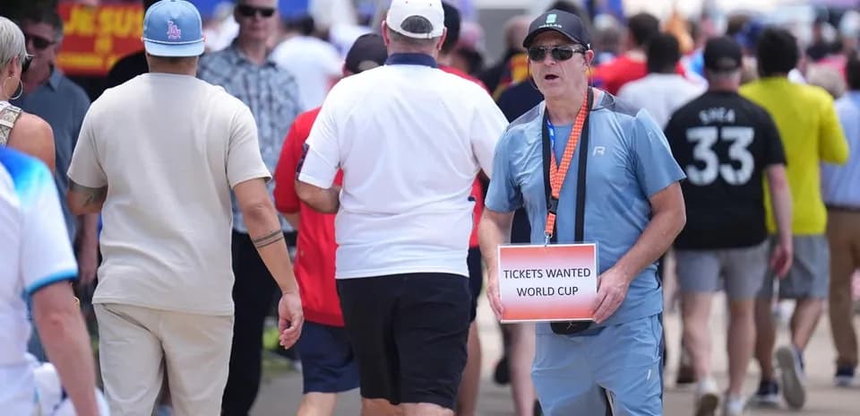 Fan holding 'Tickets Wanted World Cup' sign in crowd