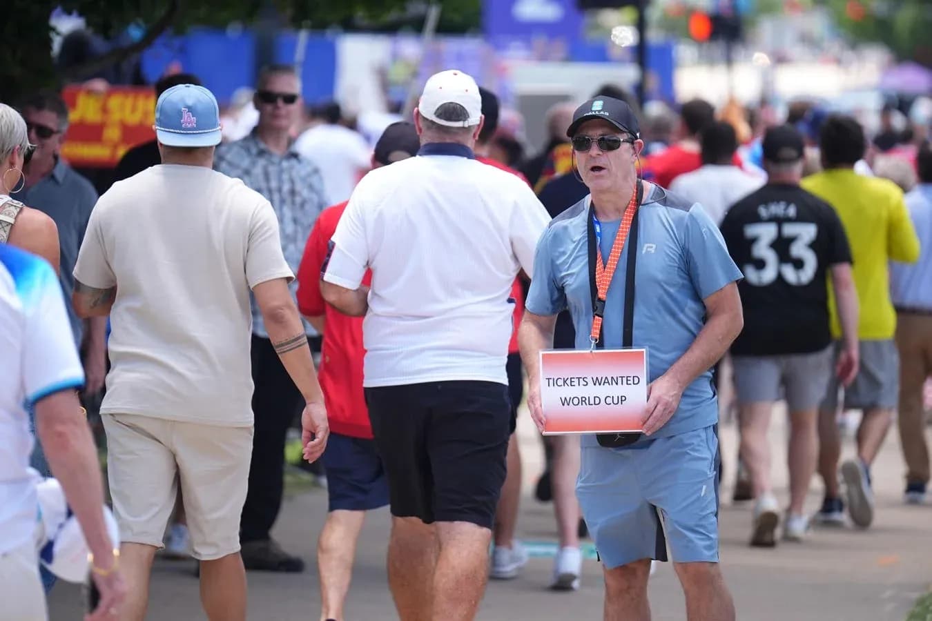 Fan holding 'Tickets Wanted World Cup' sign in crowd