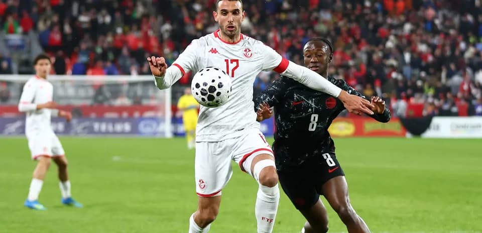 Tunisian player controlling ball during match against Canada