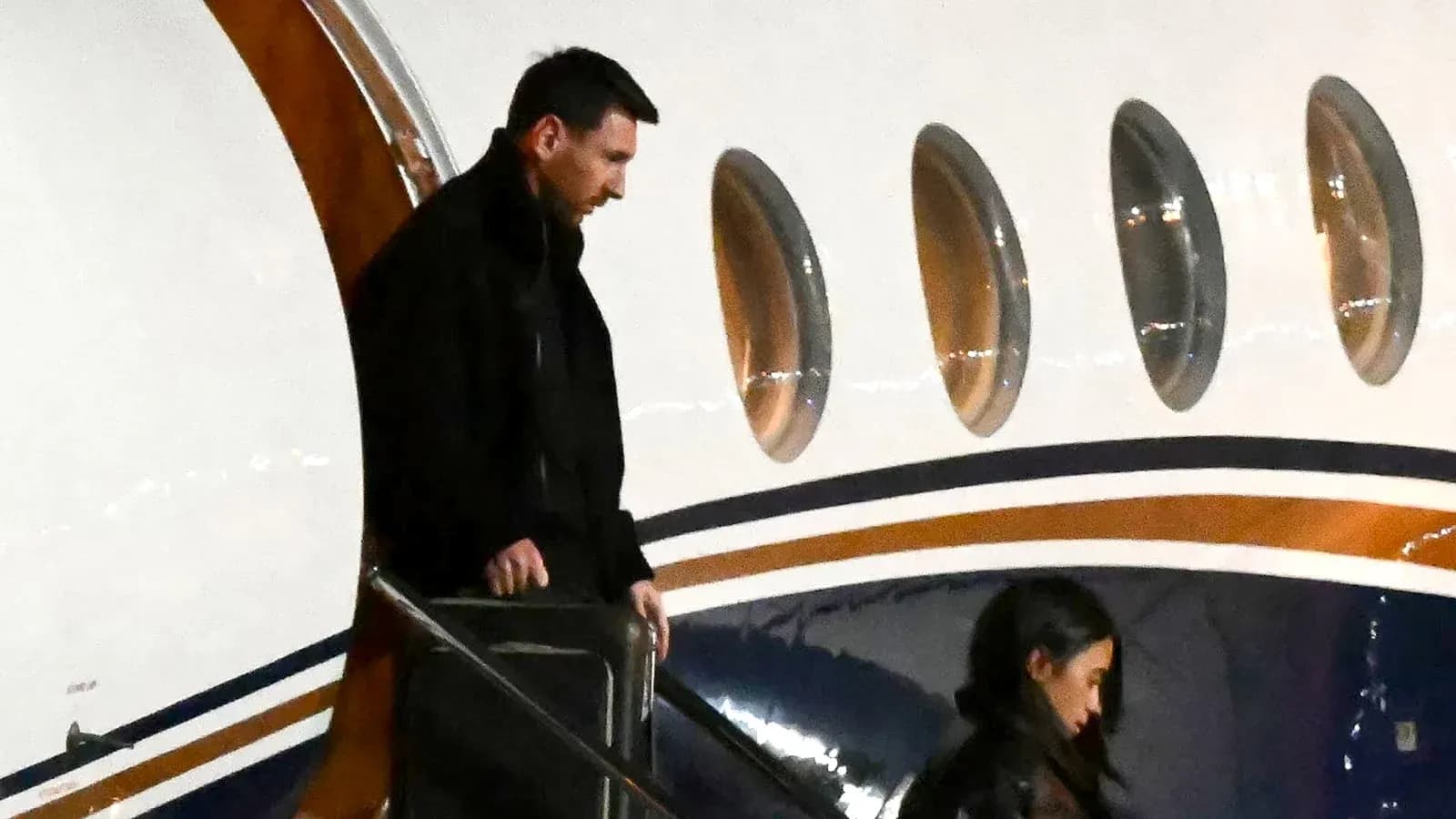 Messi descending steps from private jet