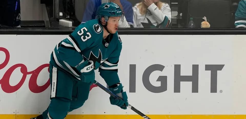 Hockey player in teal jersey during game action