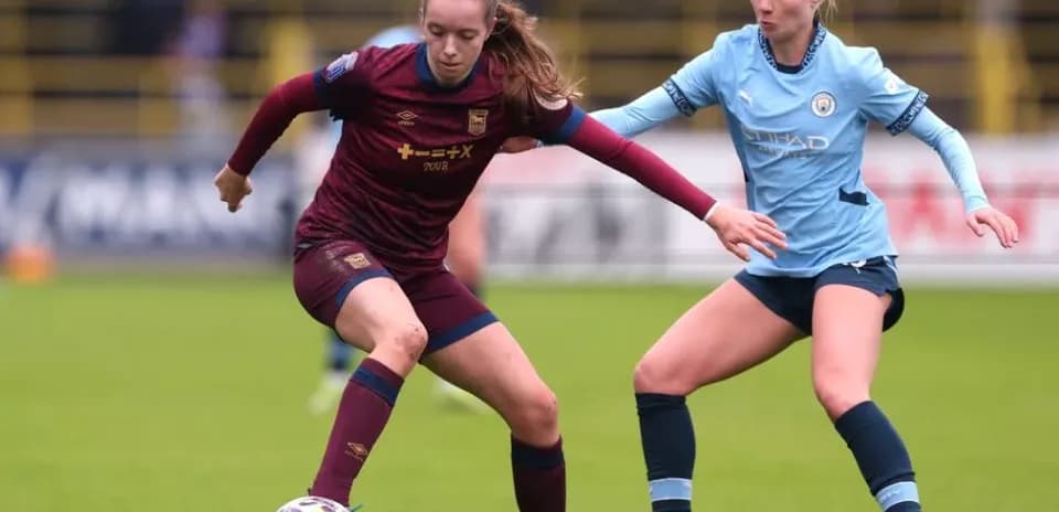 Two female players competing for the ball