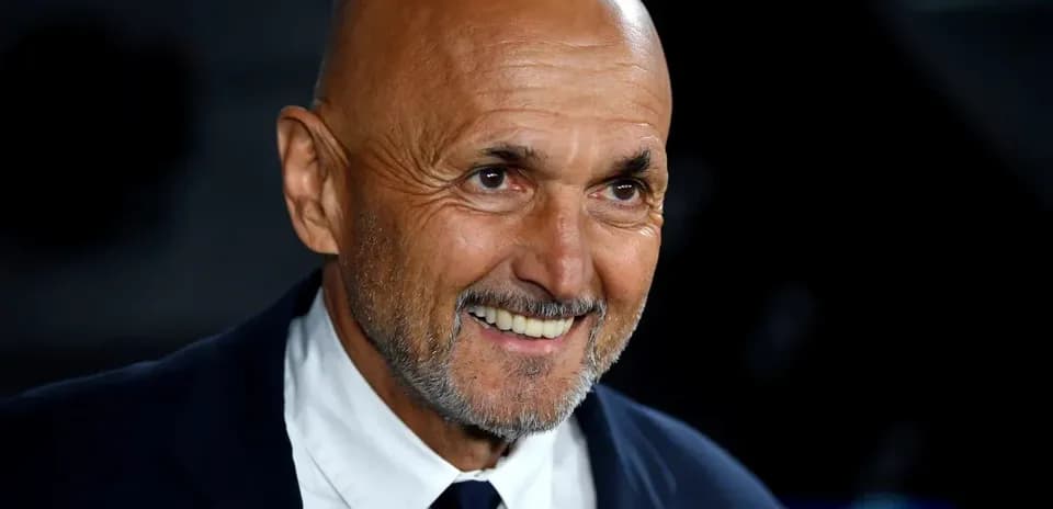 Bald man smiling in a dark setting