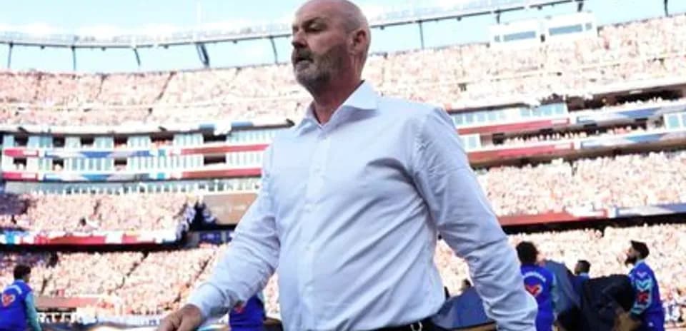 Men's football coach walking onto the pitch