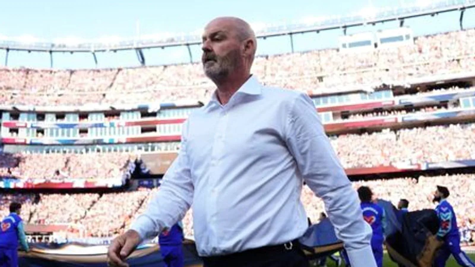 Men's football coach walking onto the pitch