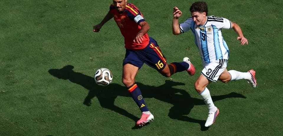 Ispaniya va Argentina o'yinchilari to'pni quvlayapti