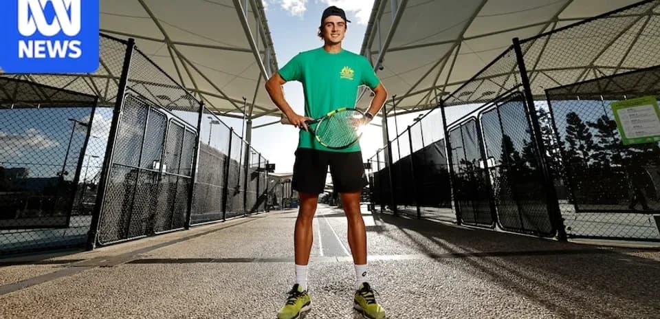 Tennis player posing with racket at court