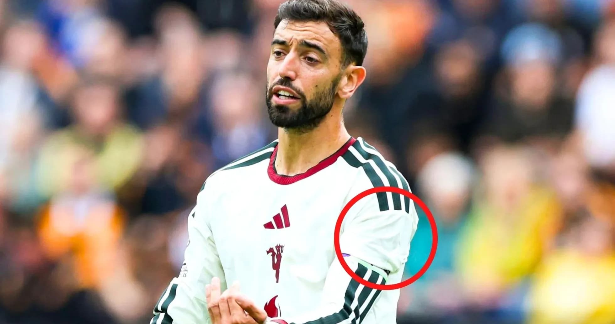 Futbolchi maydonda harakatda, o'ng qo'lini ko'targan